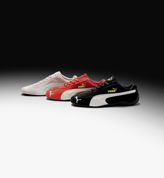 Trzy buty marki Puma w kolorach różowym, czerwonym i czarnym położone są na czarno-białym tle.