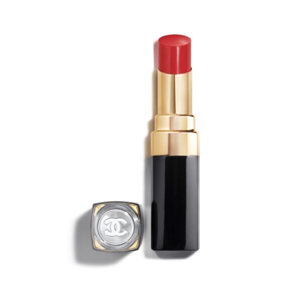 Luksusowa czerwona pomadka Chanel w eleganckim czarno-złotym opakowaniu, z przezroczystą zakrętką ozdobioną logo Chanel, przedstawiona na białym tle.