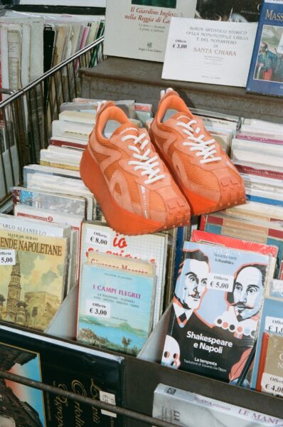 Pomarańczowe sneakersy z linii letniej INUIKII. Zdjęcie z kampanii.