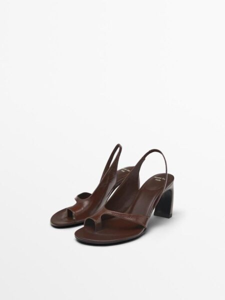 Brązowe sandały na średnim, grubym obcasie z odkrytymi palcami i paskiem typu slingback, wykonane z błyszczącej skóry, ustawione pod kątem na białym tle.