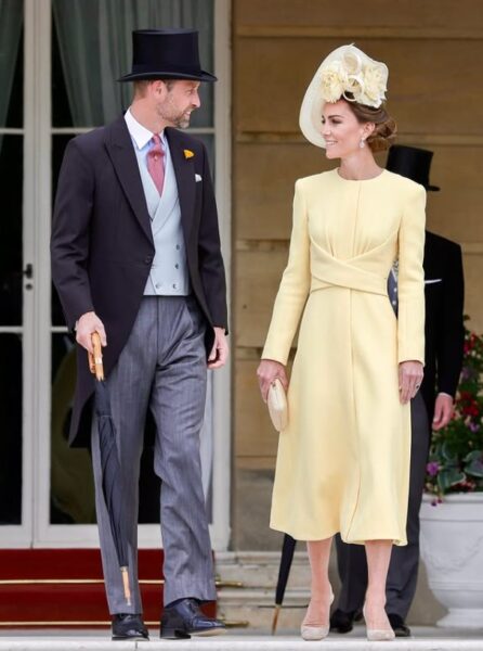 Księżna Kate w jasnożółtej sukience i książę William w ciemnoszarym eleganckim stroju.