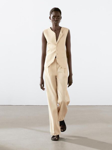 Beżowy garnitur bez rękawów z dopasowanym bezrękawnikiem i prostymi spodniami – minimalistyczny look z wiosennej kolekcji Massimo Dutti.