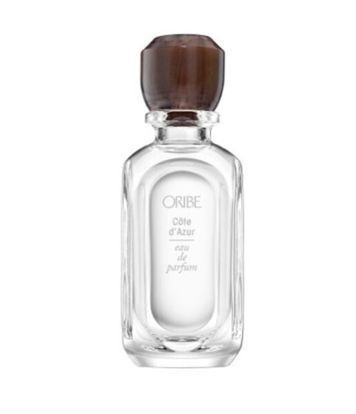 Elegancki flakon perfum Oribe Côte d’Azur Eau de Parfum z przezroczystego szkła, z brązowym, wielokątnym korkiem i delikatnym napisem na froncie.