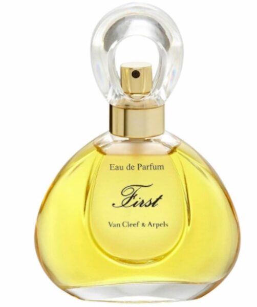 Butelka perfum Van Cleef & Arpels First Eau de Parfum, o eleganckim, zaokrąglonym kształcie z przezroczystym korkiem i złotym atomizerem, wypełniona złocistym płynem.
