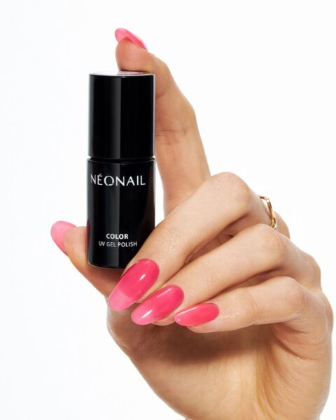 Zdjęcie dłoni z długimi, pomalowanymi na różowo paznokciami z efektem jelly nails. Dłoń trzyma buteleczkę lakieru hybrydowego marki Neonail.