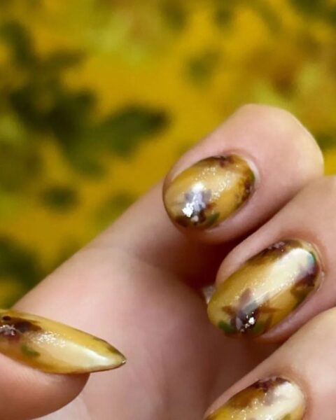 Zdjęcie manicure Blake Lively. Są pomalowane na kolor beżowy, brązowy i bordowy w kwiaty.