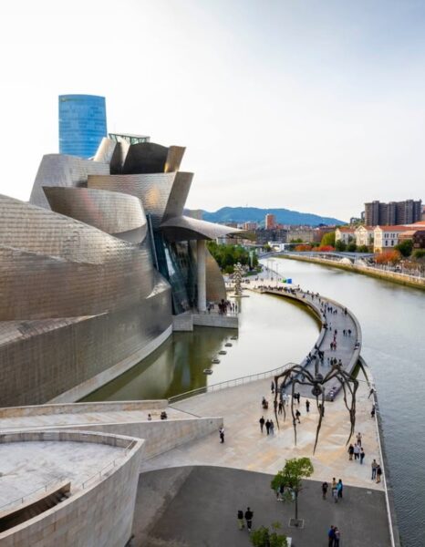 Muzeum Guggenheima w Bilbao - nowoczesny, obły budynek nad wodą.