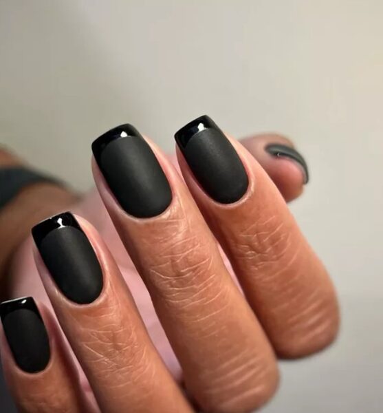 Czarny manicure ze zdobieniem francuskim.
