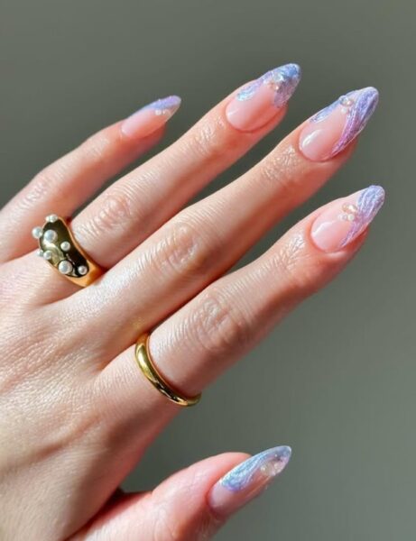 Manicure inspirowany morskimi historiami - jasna płytka, a na niej niebieskie zdobienia.