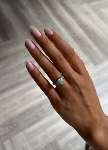 Manicure opalowy - widać kobiecą dłoń z dużym pierścionkiem.