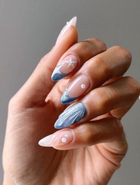 Manicure inspirowany morskimi historiami. Jasne płytki z niebieskimi elementami i muszelkowym zdobieniem.