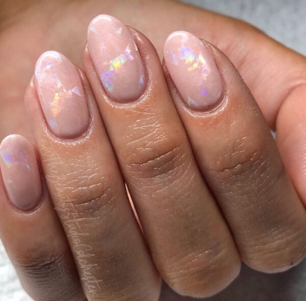 Jasny manicure z błyszczącymi elementami.