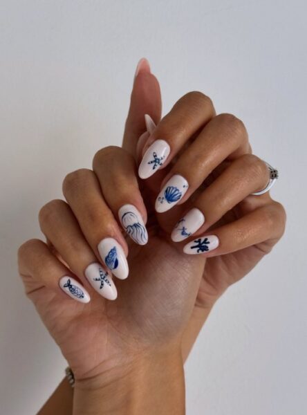 Jasny manicure z niemieckimi, morskimi wzorkami.