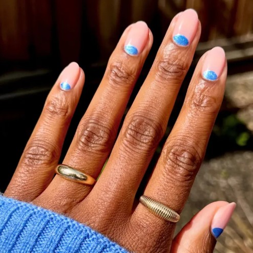 Manicure opalowy z niemieckimi elementami na dole płytki.