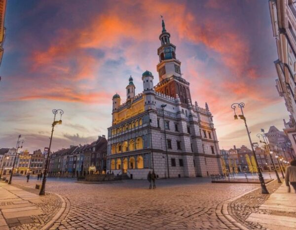 Stary Rynek w Poznaniu sfotografowany na tle zachodzącego słońca.