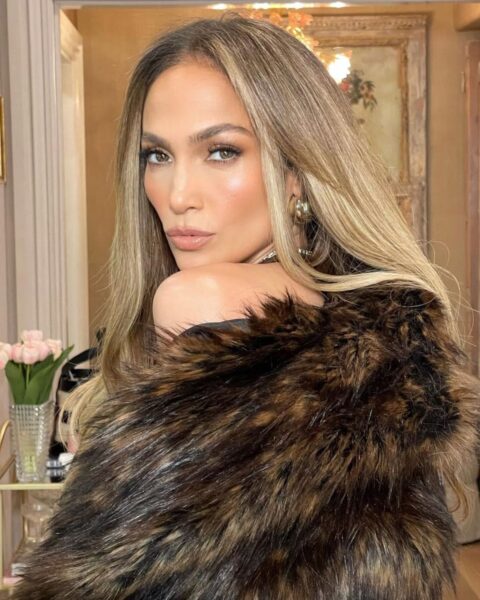 Zdjęcie Jennifer Lopez ubranej w futro. Ma rozpuszczone włosy. Pozuje półbokiem ale obraca się do obiektywu.