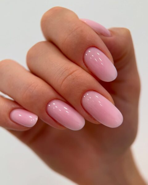 Zdjęcie dłoni ze zbliżeniem na długie, owalne paznokcie pomalowane na kolor cotton Candy pink. Dłoń układa się tak, by prezentować manicure.