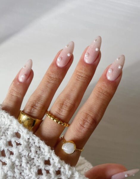 Jasny manicure z połyskiem i doklejonymi perłami.