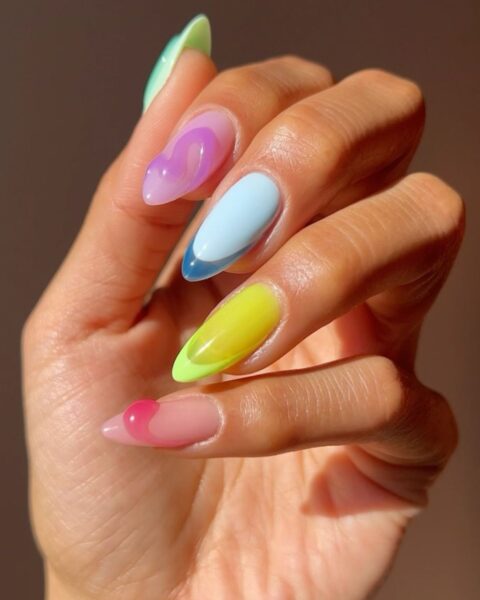 Zdjęcie dłoni z długimi, owalnymi paznokciami. To jelly french manicure w neonowych kolorach, a do tego ozdobione strukturalnym wzorem.