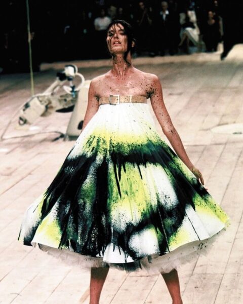 Zdjęcie podczas pokazu na sezon wiosna-lato 1999 projektant, w ramach performance'u „No. 13 Finale” kazał modelce Shalom Harlow stanąć na obrotowej platformie i pozwolił, by dwie mechaniczne maszyny przemysłowe opryskały jej białą suknię farbą.