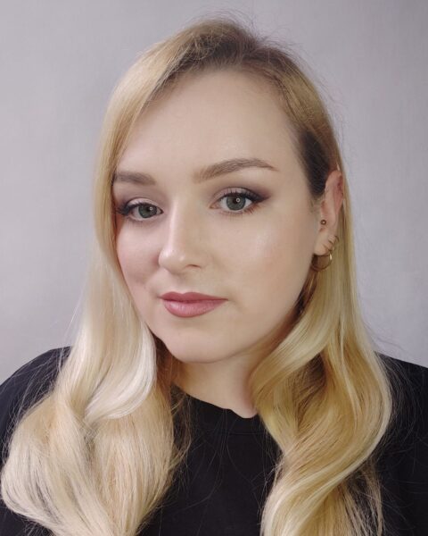 Portret kobiety z subtelnym, wieczorowym makijażem, który podkreśla oczy w odcieniach śliwki i usta w kolorze zgaszonego różu. Elegancka inspiracja na makeup-no-makeup na dojrzałej cerze: jak rozświetlić skórę, wymodelować brwi i stworzyć efekt liftingu za pomocą cieniowania powiek.
