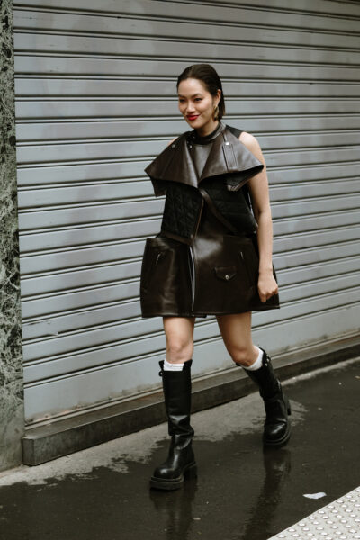 Kobieta w biker bootsach pozuje na ulicy.