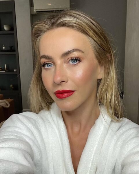 Korektor czy rozświetlacz pod oczy – a może i jedno, i drugie, by osiągnąć taki promienny blask? Jules Hough, w białym szlafroku, prezentuje makijaż Dior Beauty. Skóra twarzy jest perfekcyjnie rozświetlona i świeża, z intensywnym, lustrzanym blaskiem na policzkach. Oczy podkreśla delikatny, złoto-brzoskwiniowy cień i wytuszowane rzęsy, ale główną rolę grają tu klasyczne, matowe, czerwone usta. Makijaż jest idealnym połączeniem elegancji i hollywoodzkiego glamour.