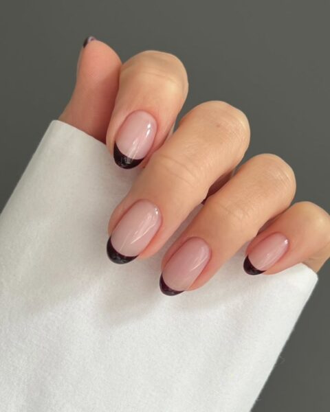 Energetyczny, pomarańczowy manicure w odcieniu intensywnej mandarynki/dyni. Krótkie paznokcie o owalnym kształcie, pokryte błyszczącym, nasyconym lakierem, który pięknie kontrastuje z opaloną skórą. Manicure idealny jako kolorowy akcent na przełomie lata i jesieni.